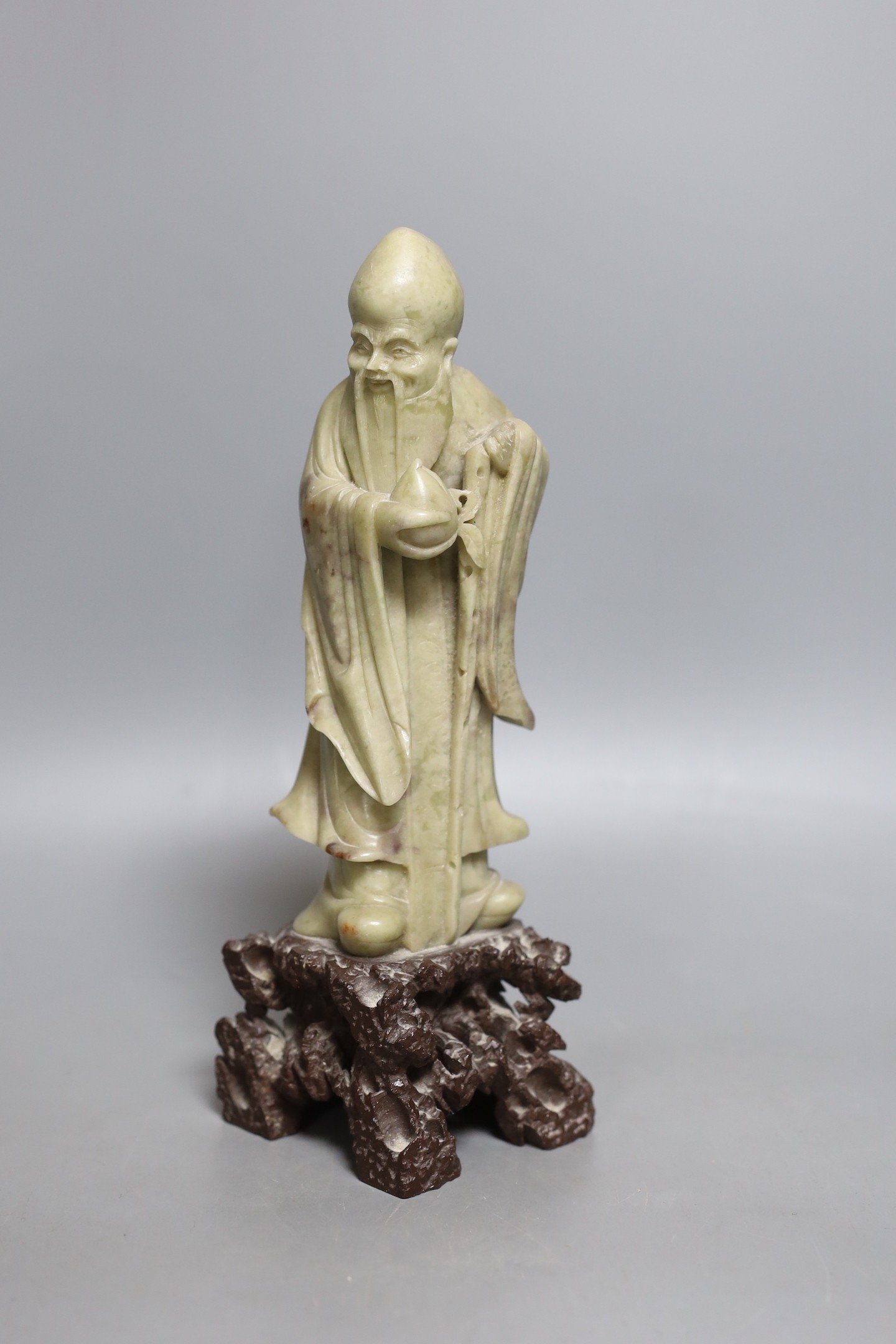 An early 20th century Chinese carved soapstone model of a sage - 23.5cm tall